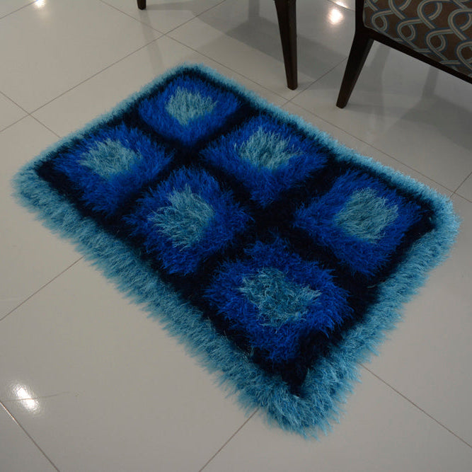 Circulo Natural Luxury Decor - Fluffy Effect Yarn, 180 m / 280 g - Blue textured rug on a white tiled floor