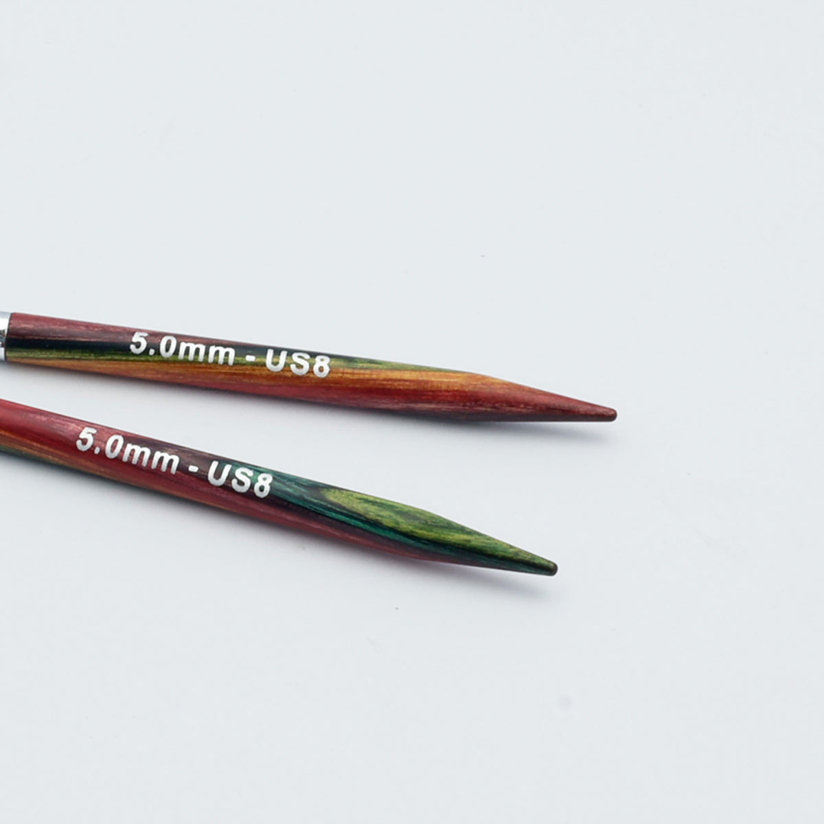 Knitpro-symfonie-2-interchangeable-needle-tips-special-10cm - Two wooden knitting needles with a red, green, and gold marbled pattern, marked with '5.0mm - US8' in white text, on a plain white background.