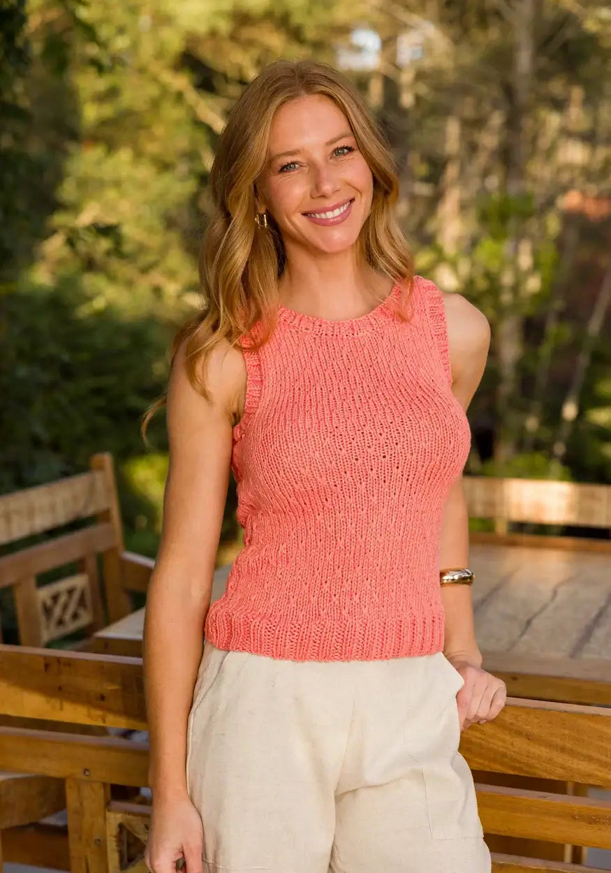 Woman wearing a coral pink top made with Circulo Aloe Vera Yarn