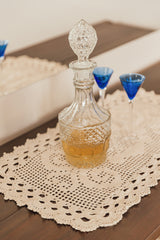 Circulo ANNE - 100% mercerized Cotton Yarn, 500m / 147g - Handmade square crochet doily made with Circulo Anne 100% mercerized cotton yarn in cream, displayed beneath a crystal decanter on a wooden table.
