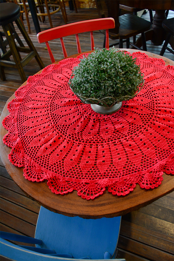 Circulo ANNE - 100% mercerized Cotton Yarn, 500m / 147g - Round wooden table with a red crocheted tablecloth and a green plant in the center.