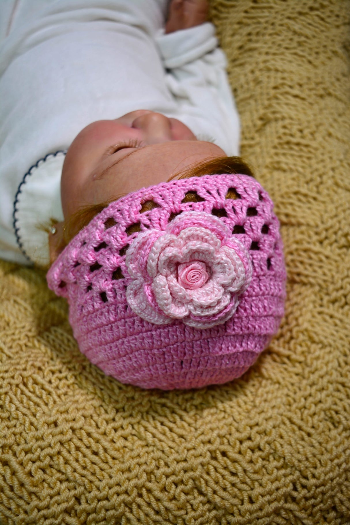 Circulo ANNE - 100% mercerized Cotton Yarn, 500m / 147g - Baby wearing a pink crochet hat with a flower on a textured yellow surface