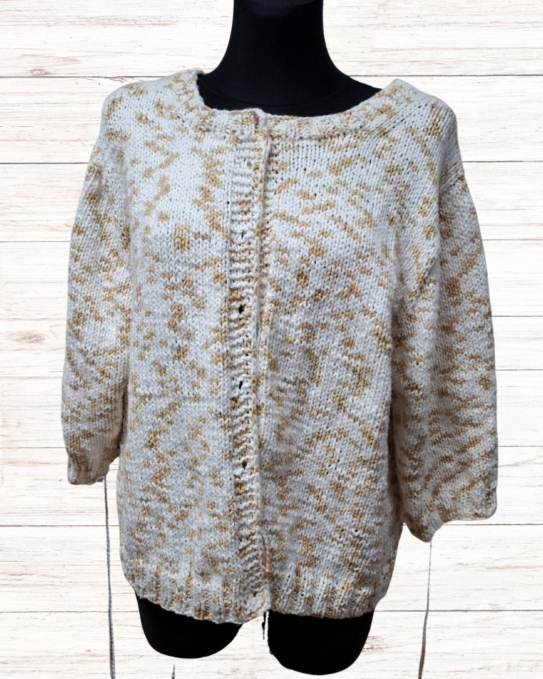 Circulo InLove  - 100% Brazilian Cotton Yarn  (125m/100g)- A chunky knit cardigan sweater with a beige and white variegated pattern, made by Mealana Austria, displayed on a black mannequin torso against a light wood plank background.