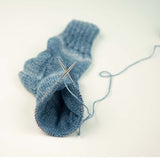 addiSockwonder Lace circular knitting needle 25cm - 710-7 - Blue knitted sock with a needle on a white background