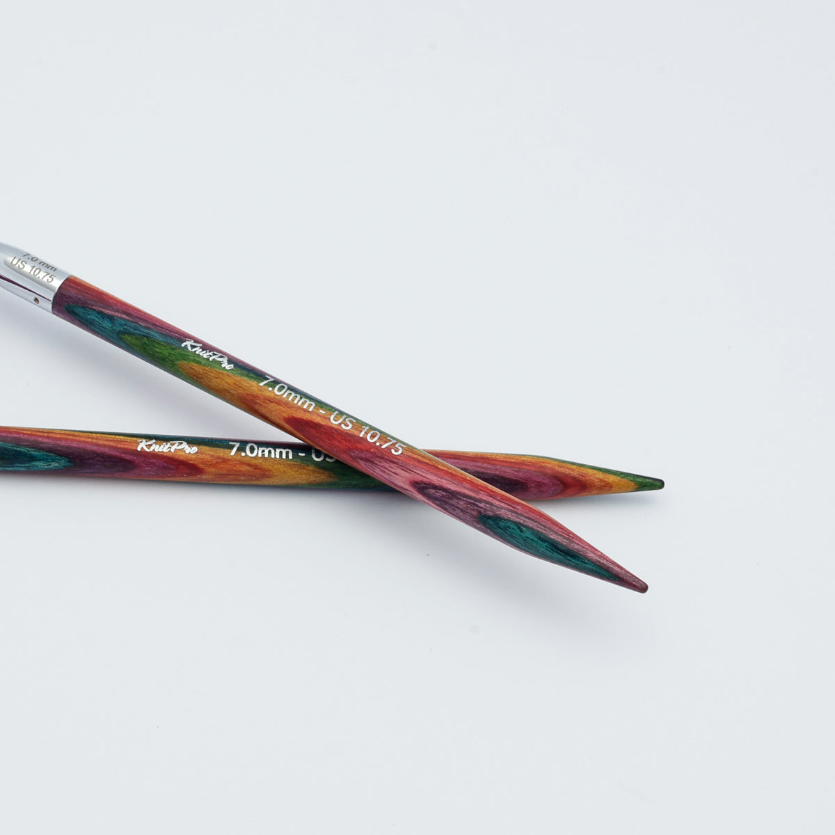 KnitPro Symfonie 2 fixed circular knitting needles with swivel cable, 60 cm - Two wooden knitting needles with a colorful, marbled pattern of red, green, and orange, crossed on a plain white background. The brand name 'Kreft' is printed in white on the shafts.