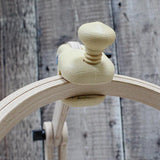 Nurge seated embroidery stand with adjustable wooden frame.